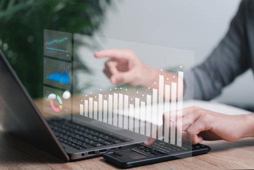 Person on laptop pointing to chart